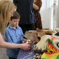 Staff member showing child a mask