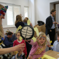 Staff member showing craft object to three children