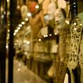 Photo of a display case in the Pitt Rivers Museum taken side on to show carved wooden objects and Japanese not masks and the subtle reflections of gallery lighting.