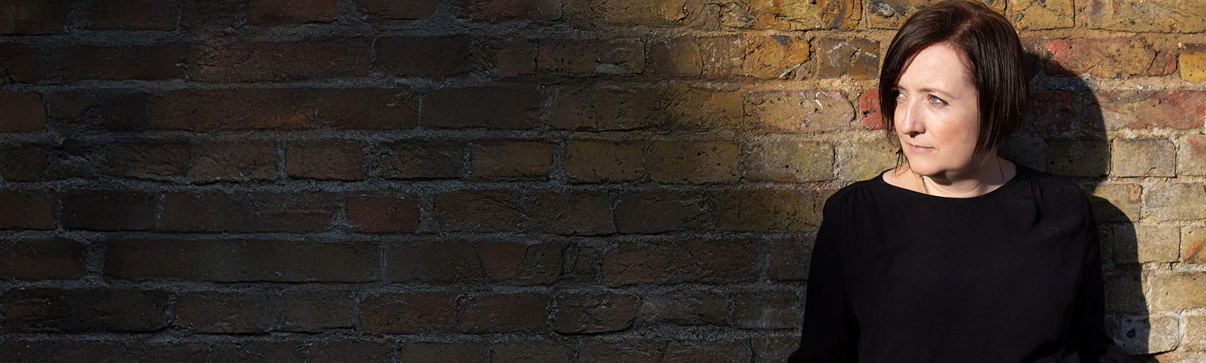 Composer Ellie Wilson pictured against a brick wall