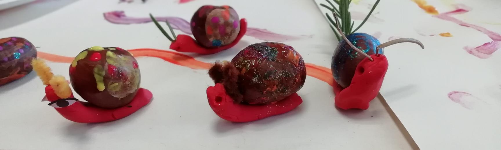 Snails made from plasticine, painted pebbles, rosemary and stick-on eyes