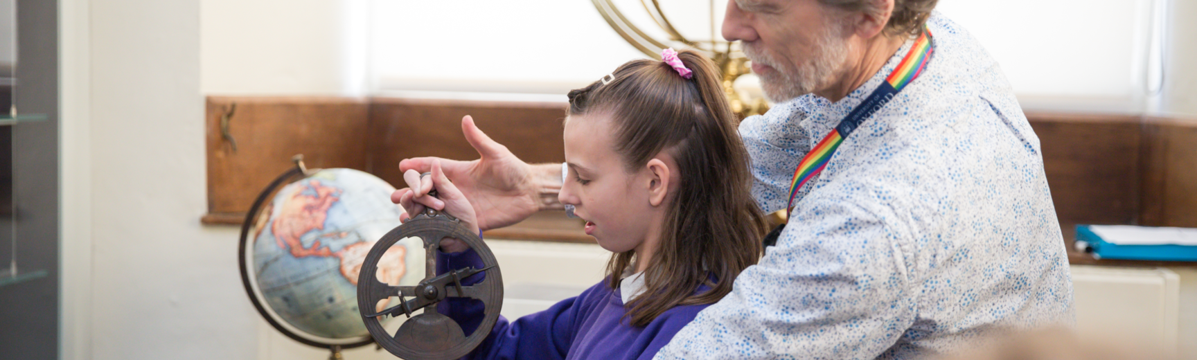 Staff showing student how to use astrolabe