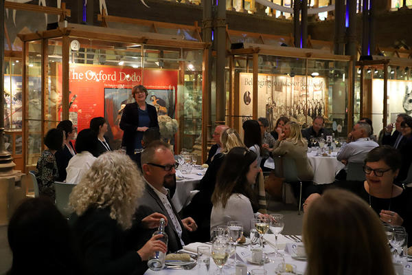 Adults sat down at tables for dinner in a museum