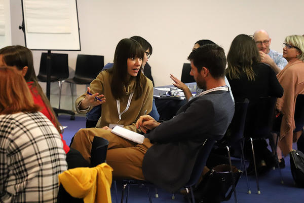 Adults discussing in pairs in a seminar room