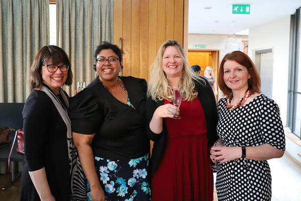 Four women smiling at an event