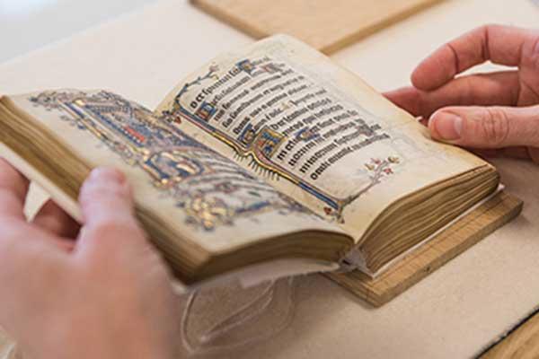 Person handling book of prayers from Bodleian Libraries' Special Collections