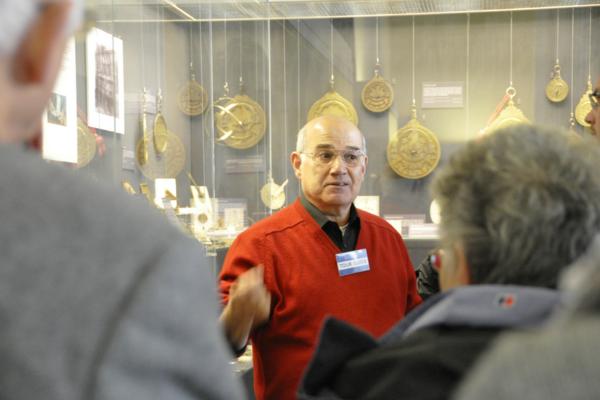Volunteer tour guide telling visitors about scientific instruments