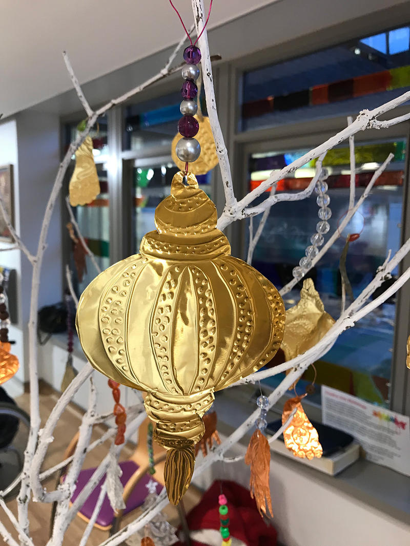 Golden artworks hanging from white branches
