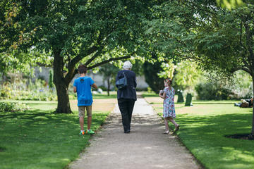 Two children and grandparent walking in botanic garden