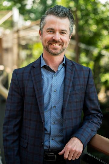 Gentleman wearing a navy, checked suit and a pale blue shirt. 