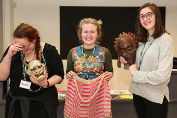 Pitt Rivers volunteers posing with masks and a bag