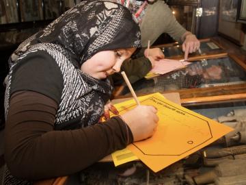 Young refugee takes part in activity at the Pitt Rivers Museum