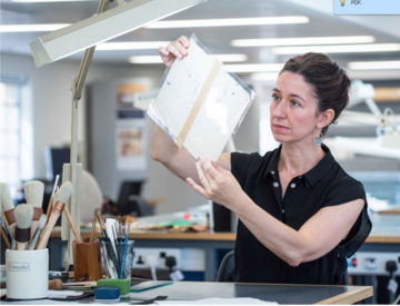 Conservator holding and examining paper document