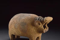 A small, orangey/brown Egyptian clay figure created in the stylised shape of a hippo.