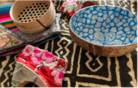 several colourful bowls and shoes are laid out on a black and beige rug
