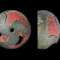 Bronze stud with curved triskele design filled with red enamel