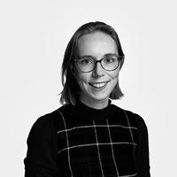 Black and white headshot of staff member Cathy King, who wears glasses and has shoulder-length hair. 