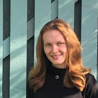 Image of a woman standing in front of a gate