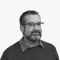 Black and white headshot photograph of a gentleman wearing top-rimmed glasses. 